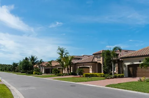 A Florida neighborhood street lined with palms and tile-roof homes