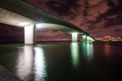 The John Ringling Causeway bridge lit up at night over Sarasota Bay